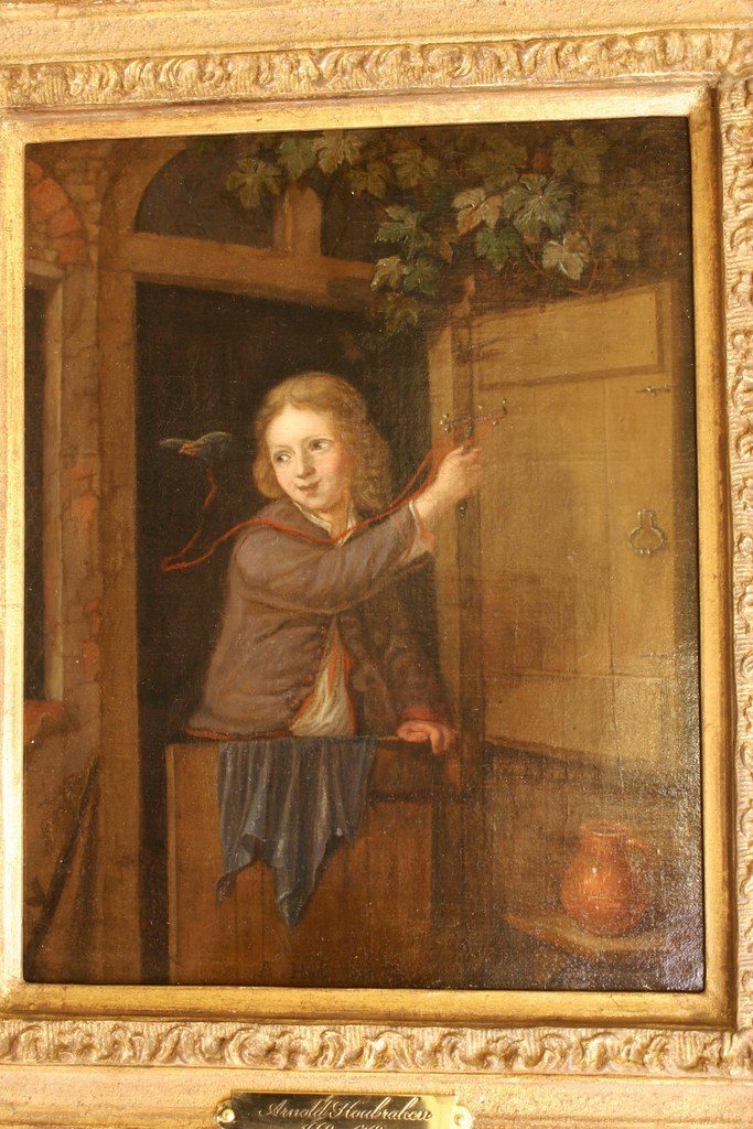 Arnold Houbraken 1660-1719 - A boy standing in a doorway holding  a finch on a string, Oil on canvas