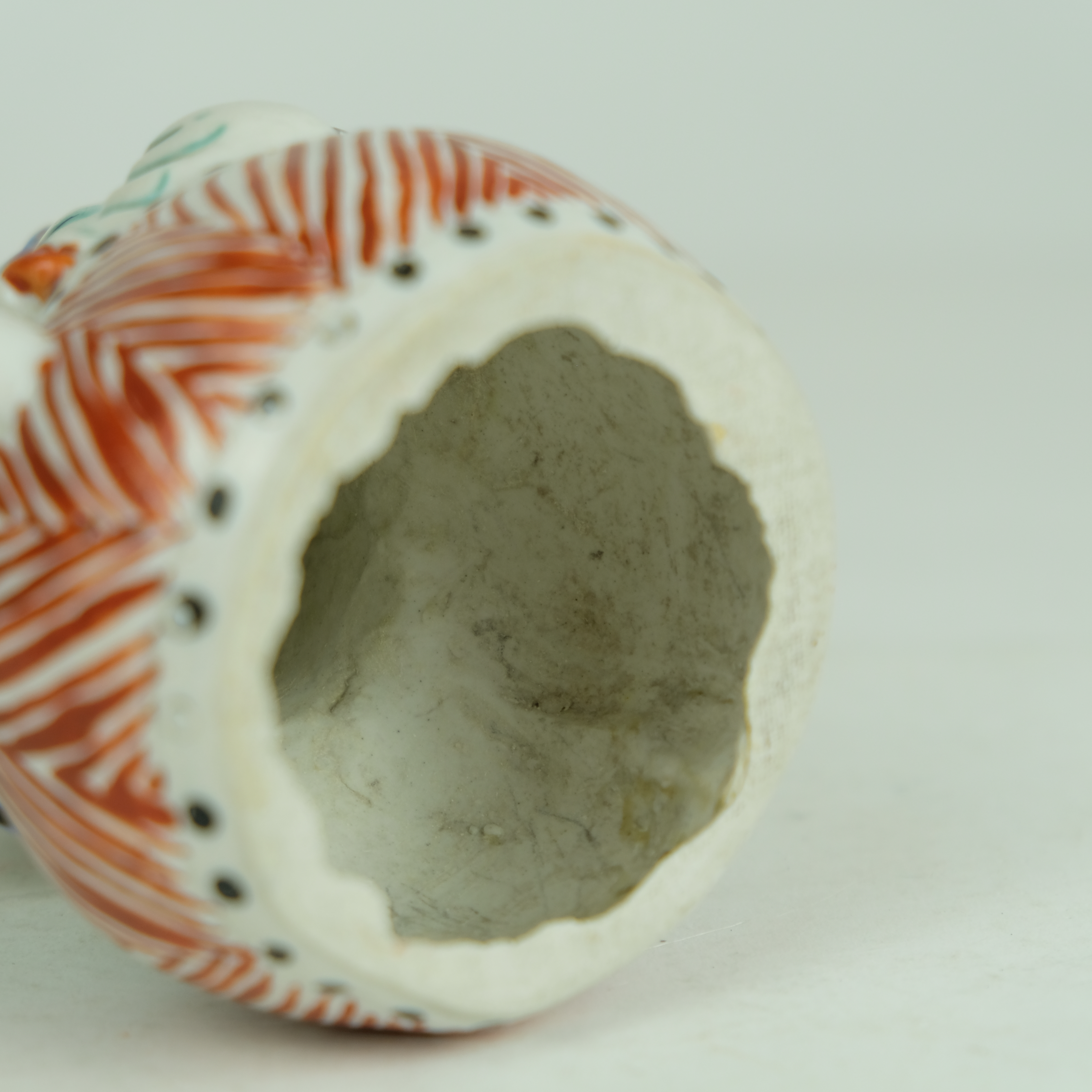 Japanese Kakiemon figure of a boy sitting on a drum. - Detail