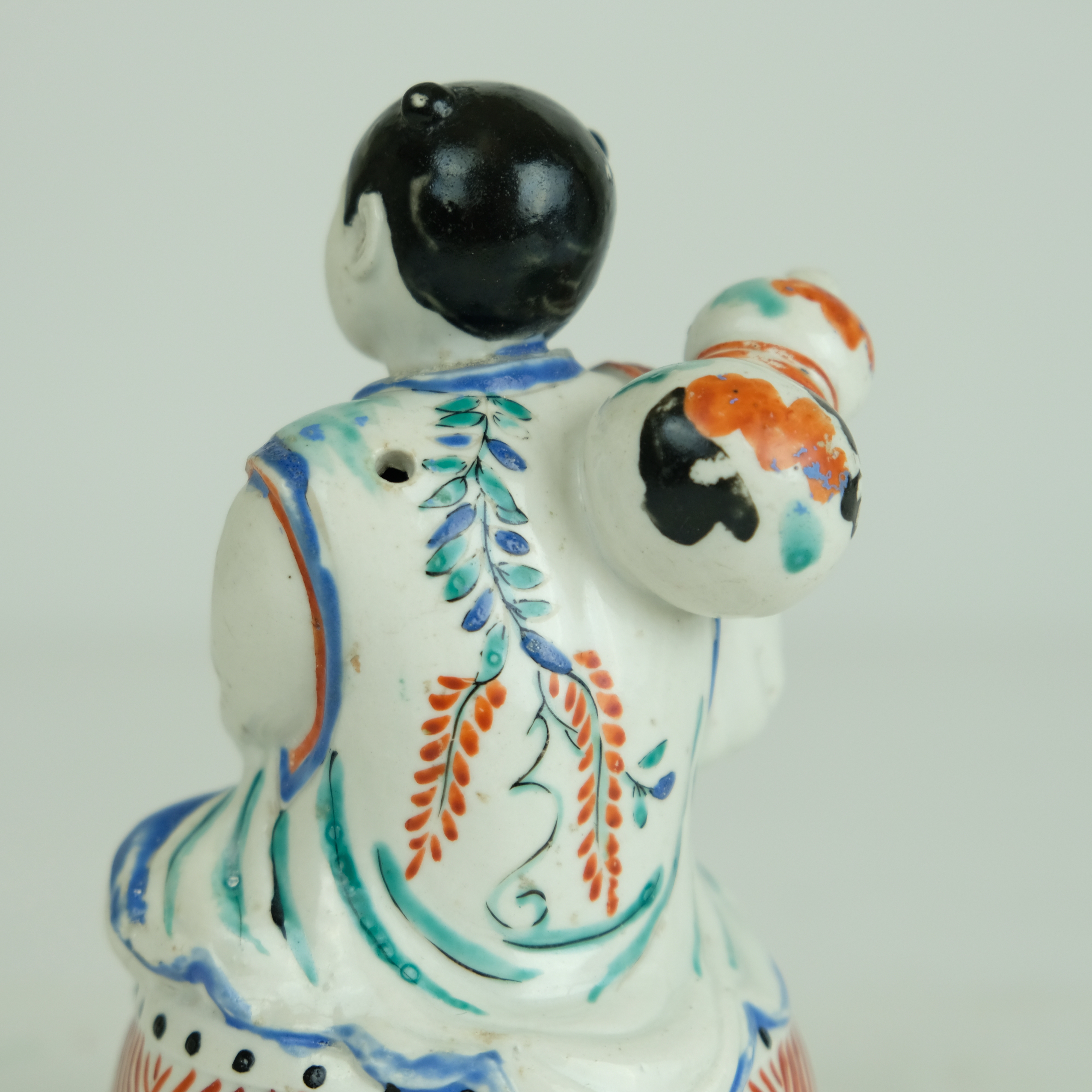 Japanese Kakiemon figure of a boy sitting on a drum. - Detail